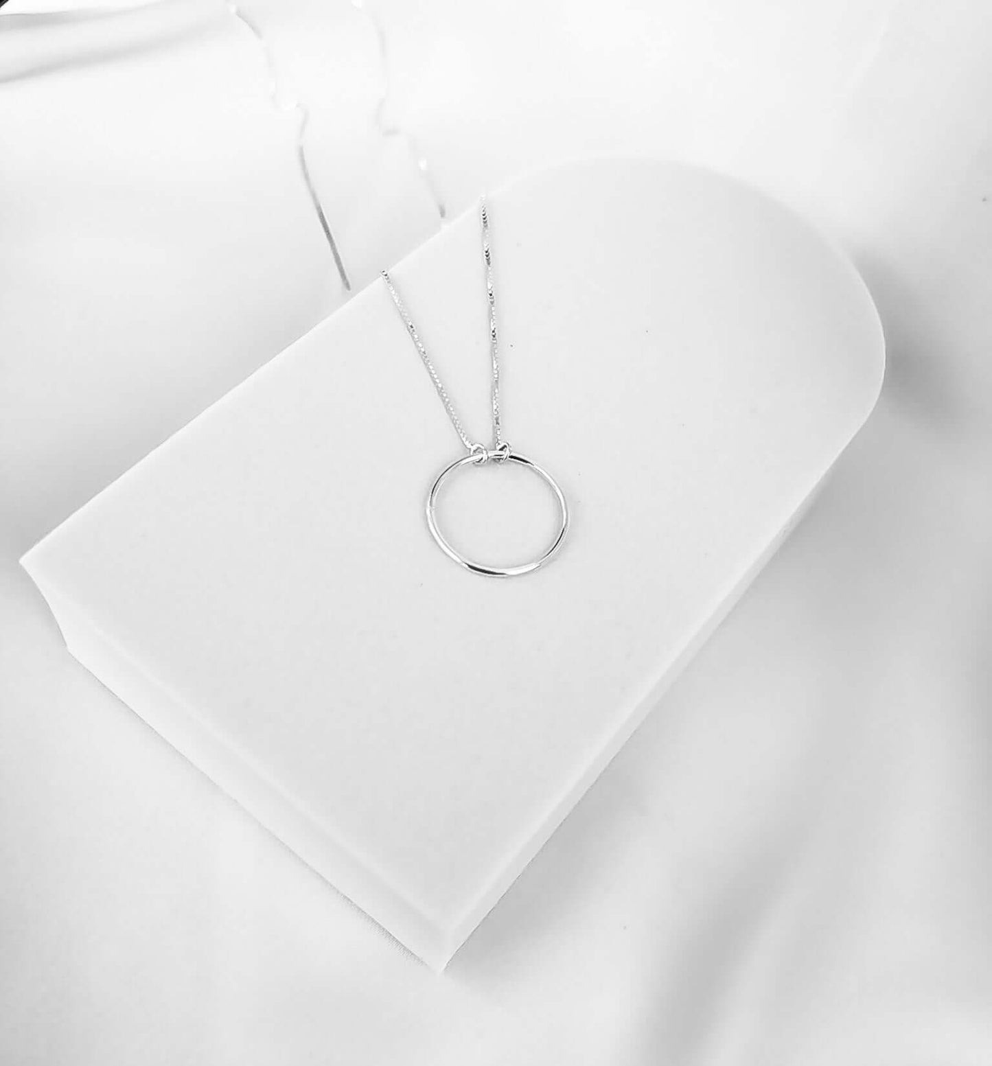Colar com Círculo Vazado Prata 925 sobre suporte branco, destacando seu design minimalista e moderno.