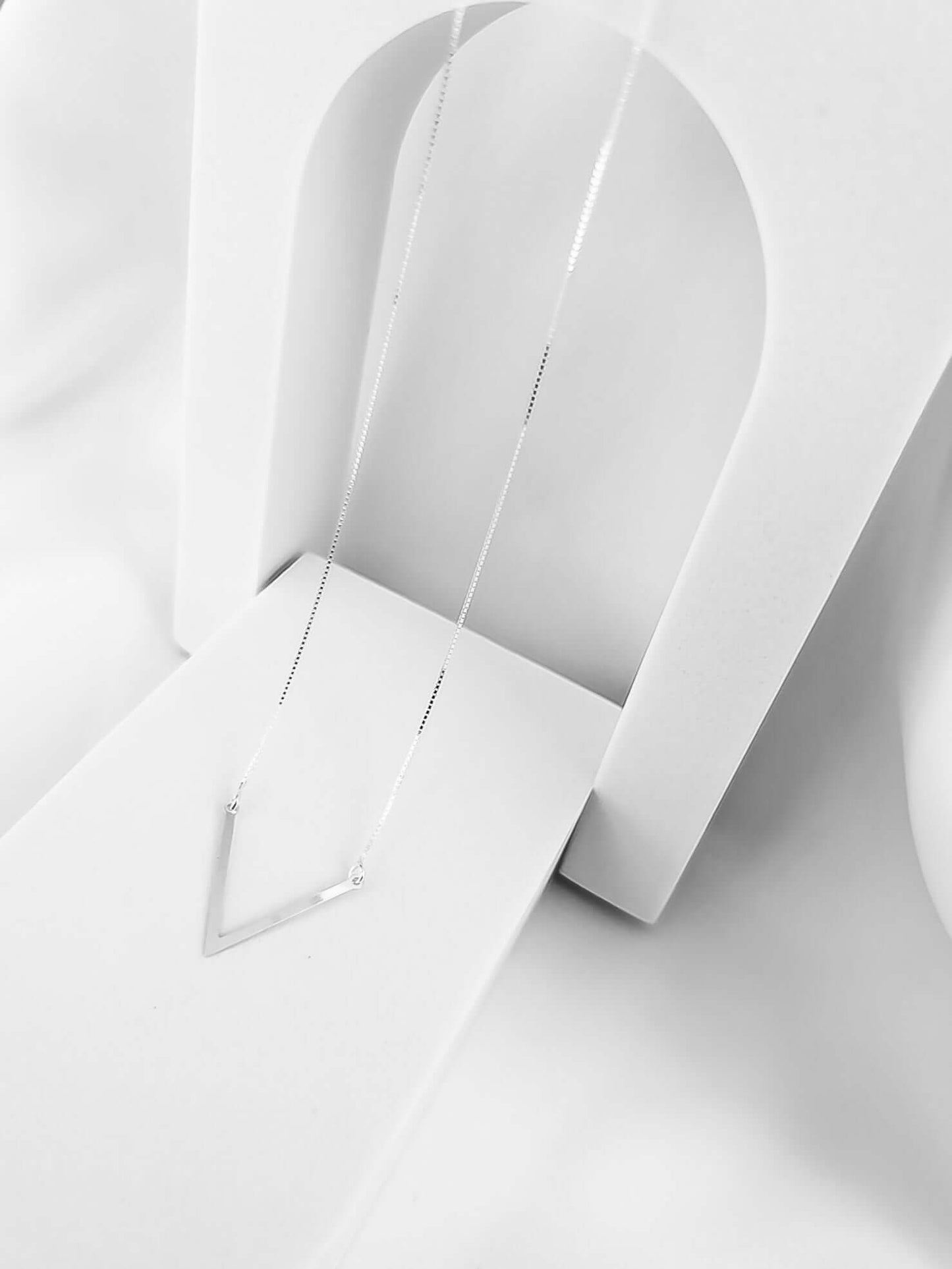 Colar V Prata 925 delicado com pingente em formato de 'V', exposto em uma apresentação minimalista.